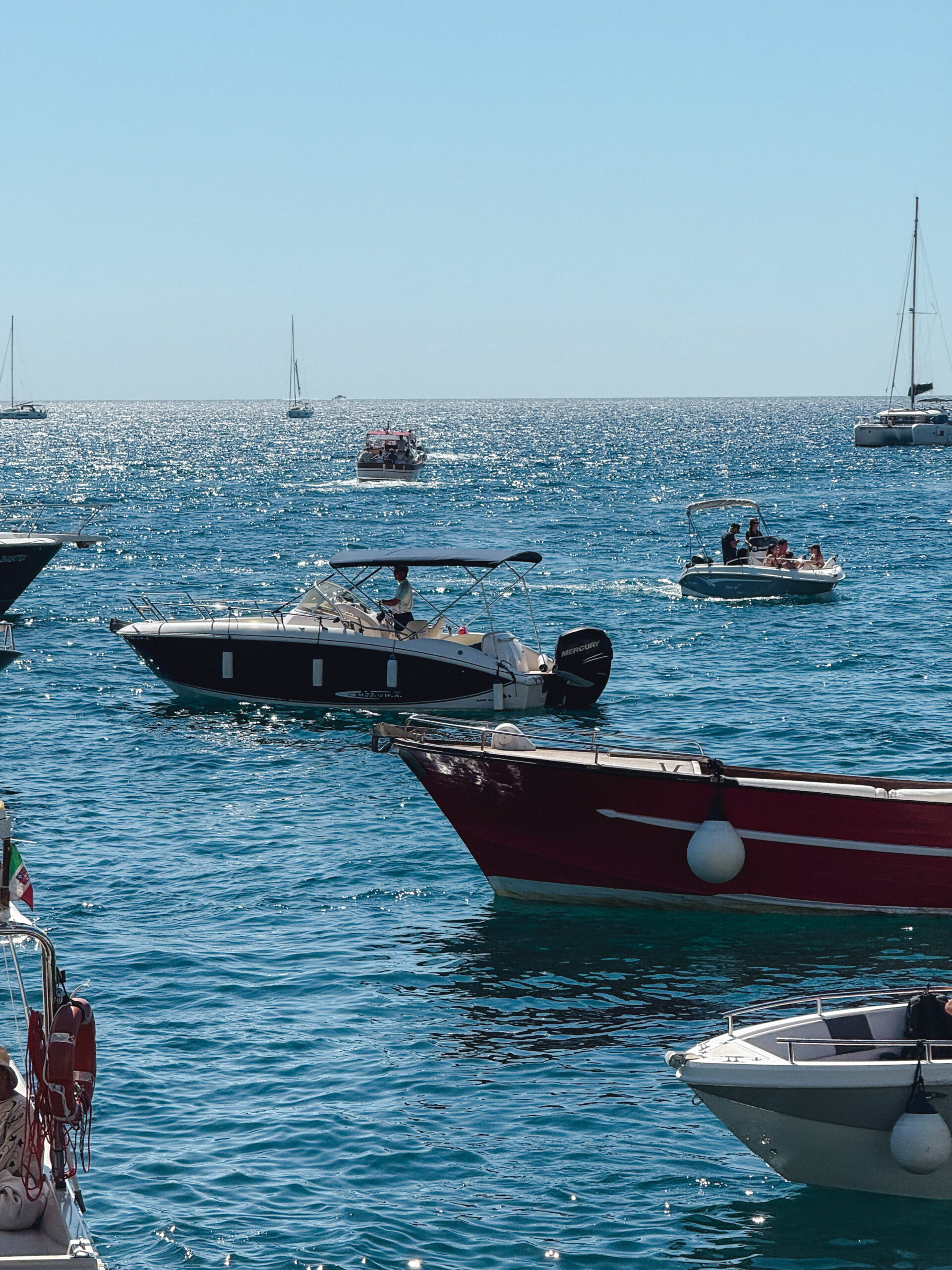 Boats floating on the sparkling blue water along the Amalfi Coast in Italy