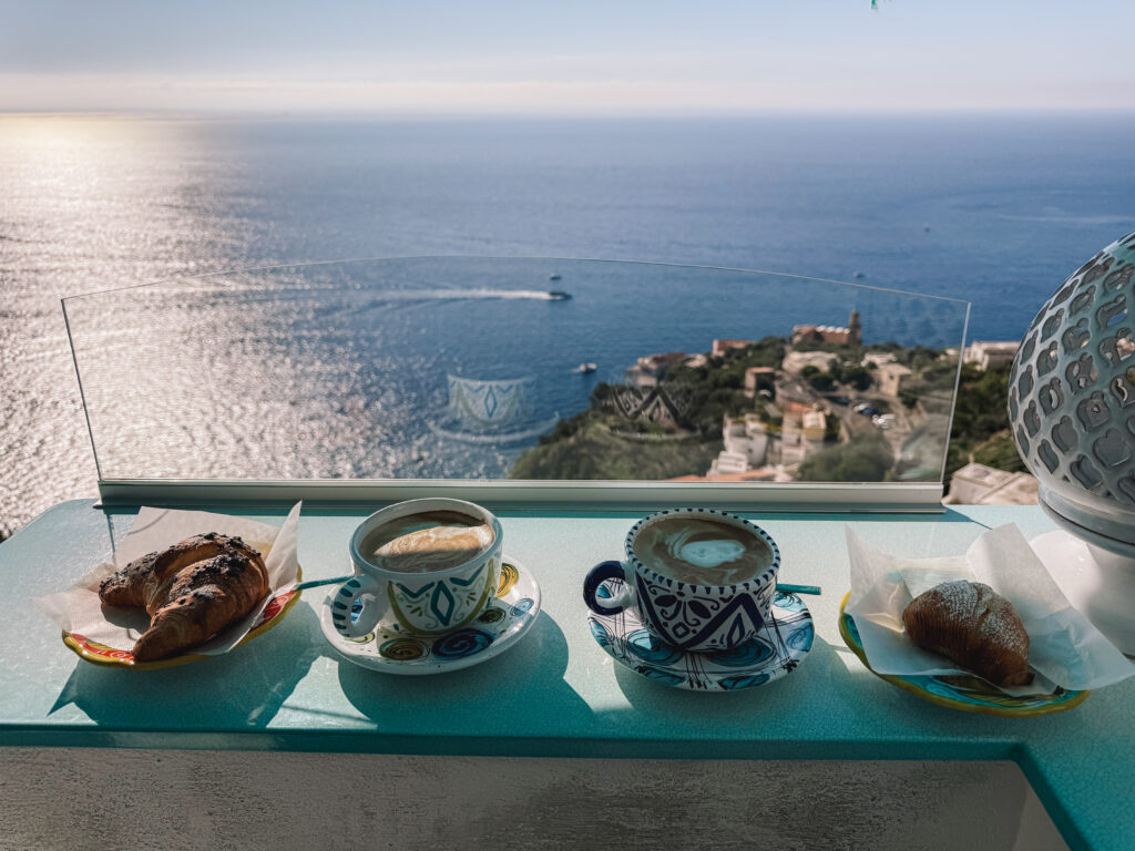 Coffee and pastries overlooking the sea from a cliffside café on the Amalfi Coast in Conca dei Marini, Italy.