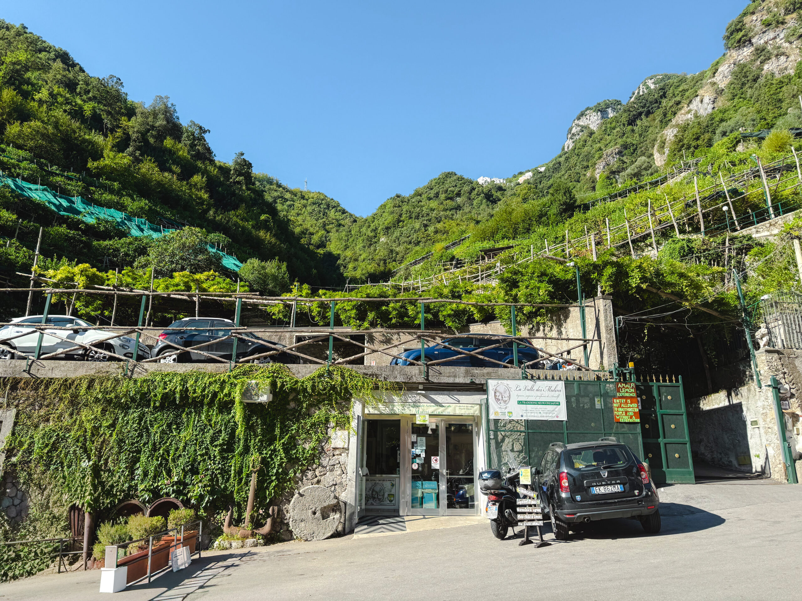 Entrance to a traditional lemon farm in Amalfi, Italy surrounded by terraced mountains.
