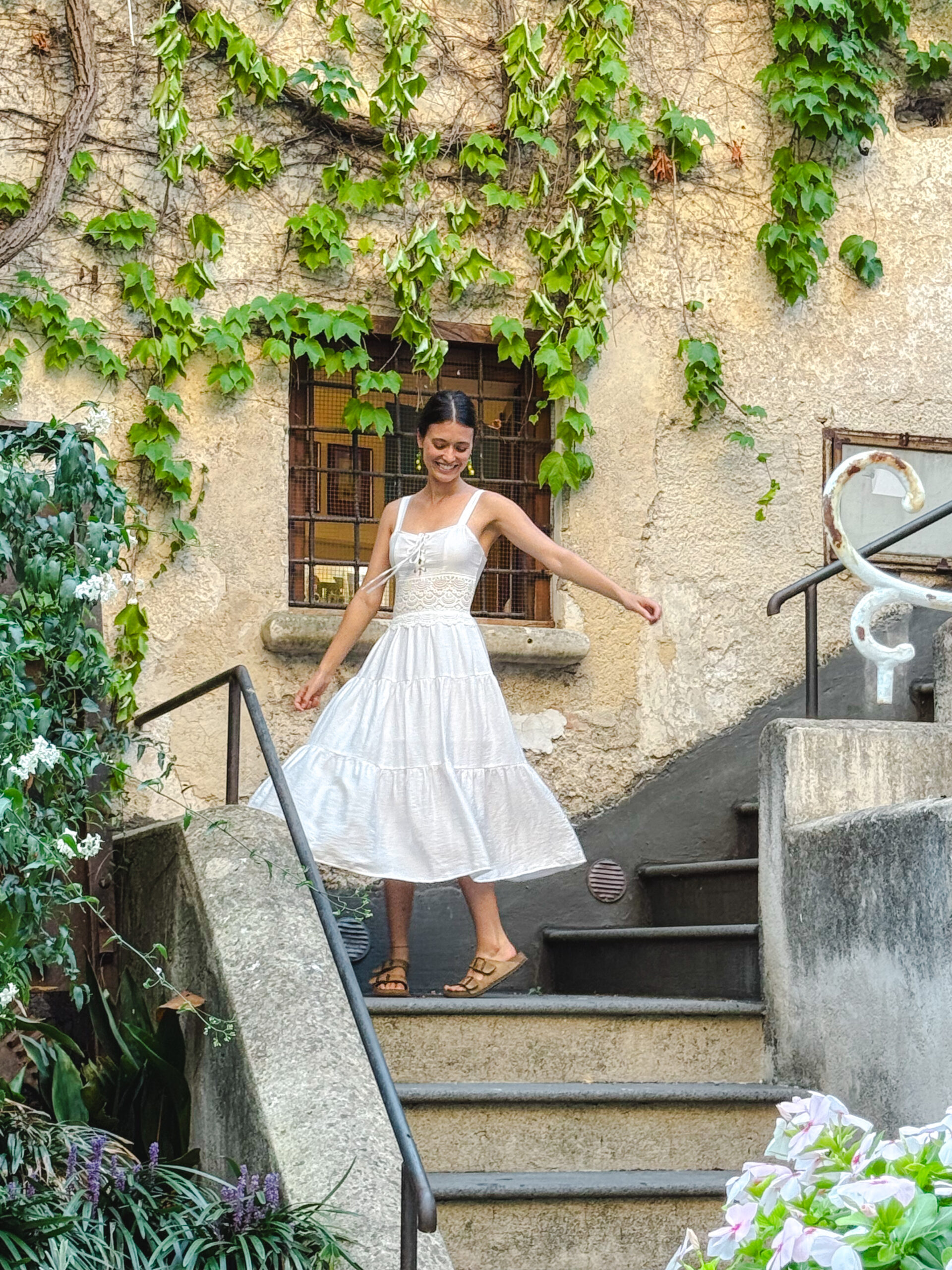 Woman dancing beneath ivy-covered walls on the Amalfi Coast in Italy